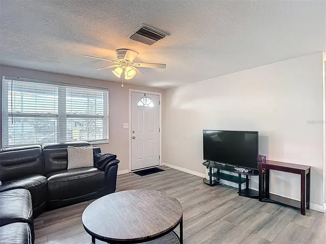 a living room with furniture and a wooden floor