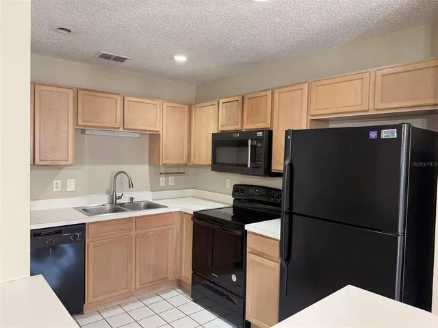 a kitchen with a sink a stove a refrigerator and cabinets