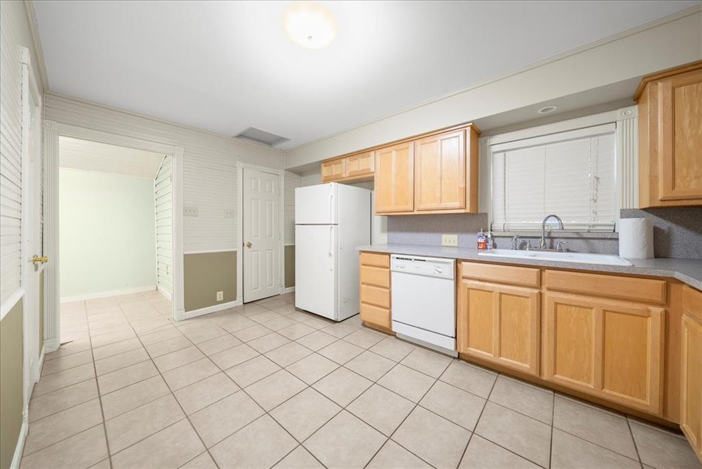 101 North 7th Street Krum, TX 76249 - Photo 18 of 26 Kitchen with light brown cabinets, white appliances, light countertops, and light tile patterned floors