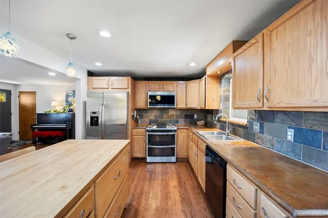a kitchen with stainless steel appliances kitchen island granite countertop a stove sink and cabinets