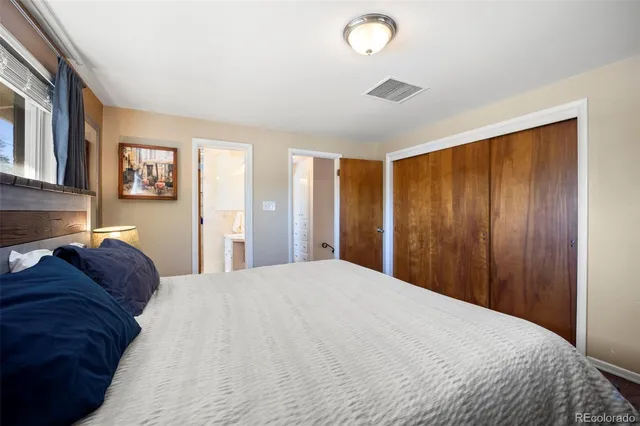a large bed in a bedroom next to a window