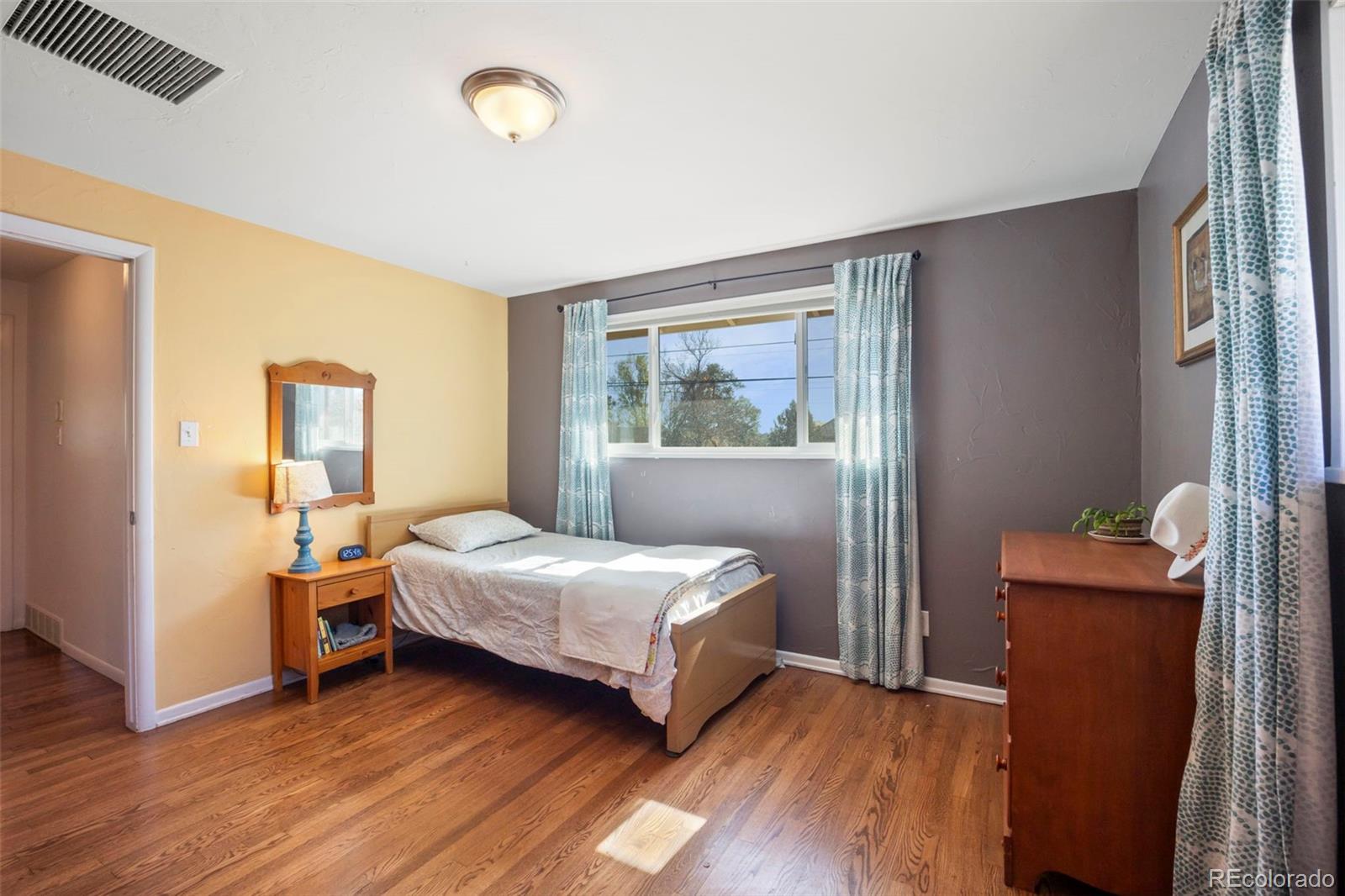 2605 Reed Court Wheat Ridge, CO 80033 - Photo 26 of 49 a bedroom with a bed and wooden floor
