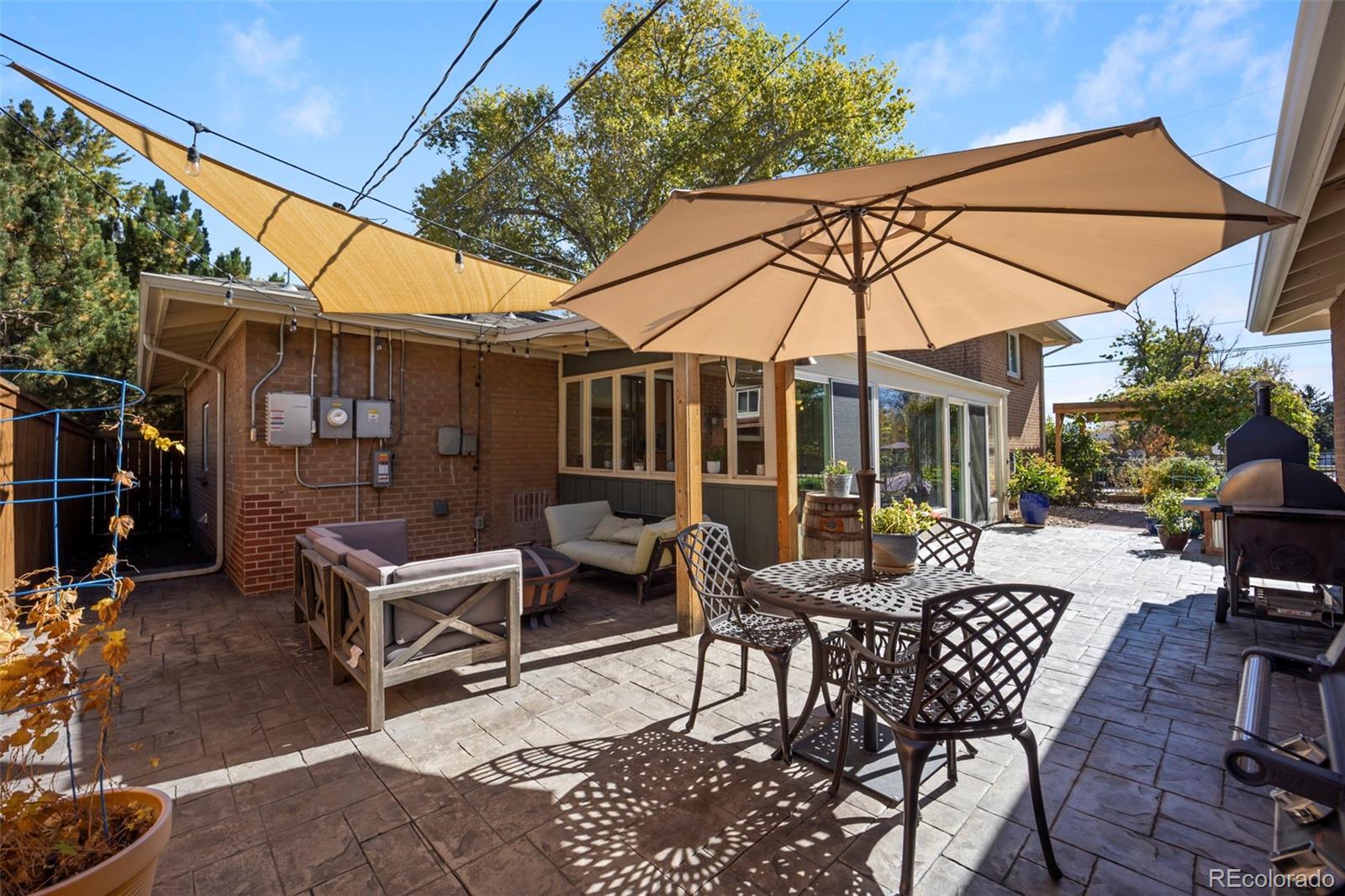 2605 Reed Court Wheat Ridge, CO 80033 - Photo 38 of 49 a view of a patio with a dining table and chairs under an umbrella