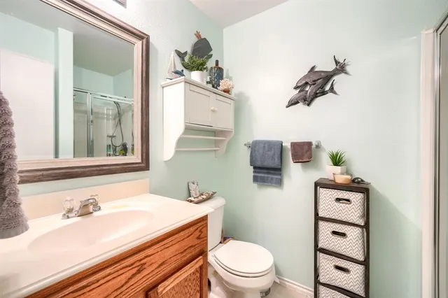 a bathroom with a granite countertop toilet sink and mirror