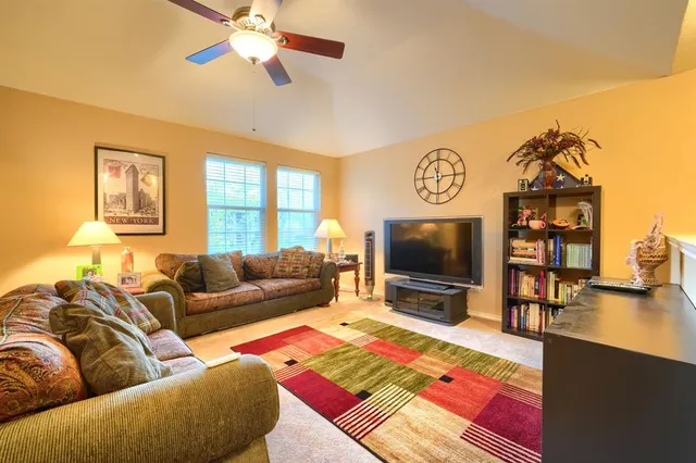 a living room with furniture ceiling fan and a rug