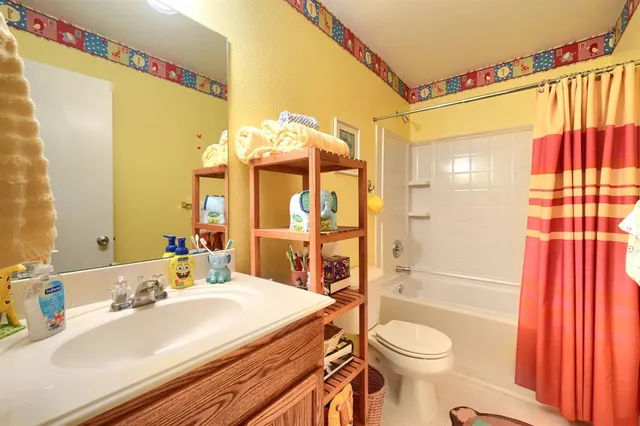 a bedroom with a bed and a flat tv screen on dresser