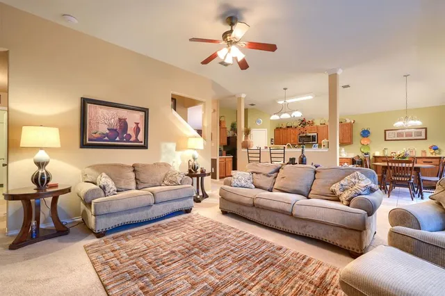 a living room with furniture ceiling fan and a rug
