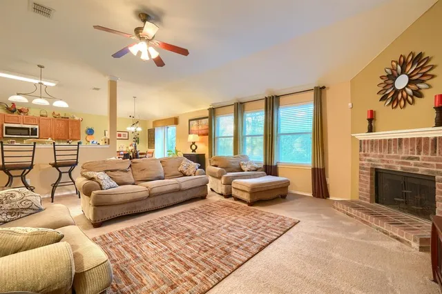 a living room with furniture fireplace and a large window