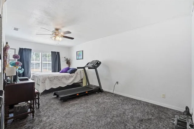a bedroom with a bed chandelier and a window