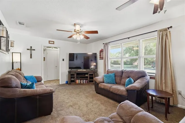 a living room with furniture a flat screen tv and a large window