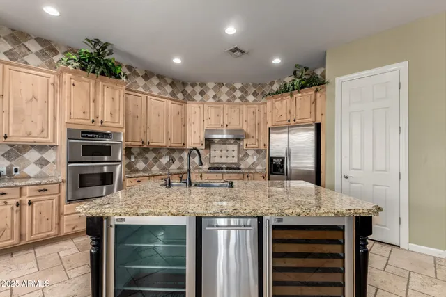 a kitchen with kitchen island granite countertop stainless steel appliances and white cabinets