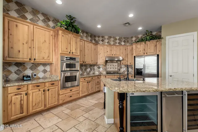 a view of kitchen with stainless steel appliances granite countertop a stove top oven a sink dishwasher and a refrigerator