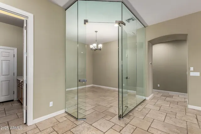 a view of a hallway with chandelier and dining area