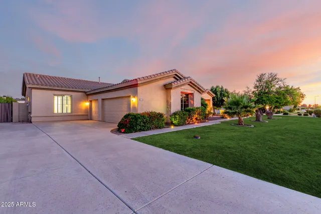 a view of a house with a big yard and large tree
