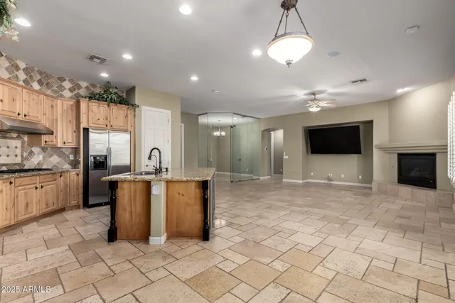 a view of an empty room with window and chandelier fan