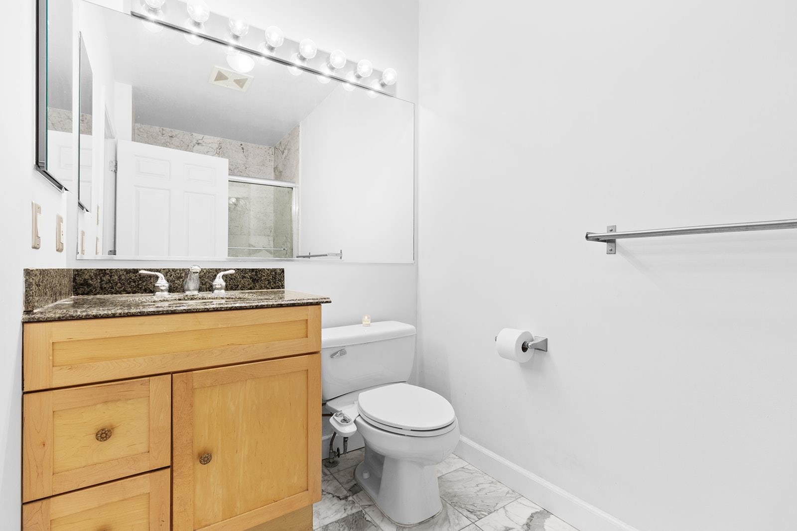 154 The Promenade, Unit 154 Edgewater, NJ 07020 - Photo 11 of 12 a bathroom with a granite countertop sink mirror vanity and toilet