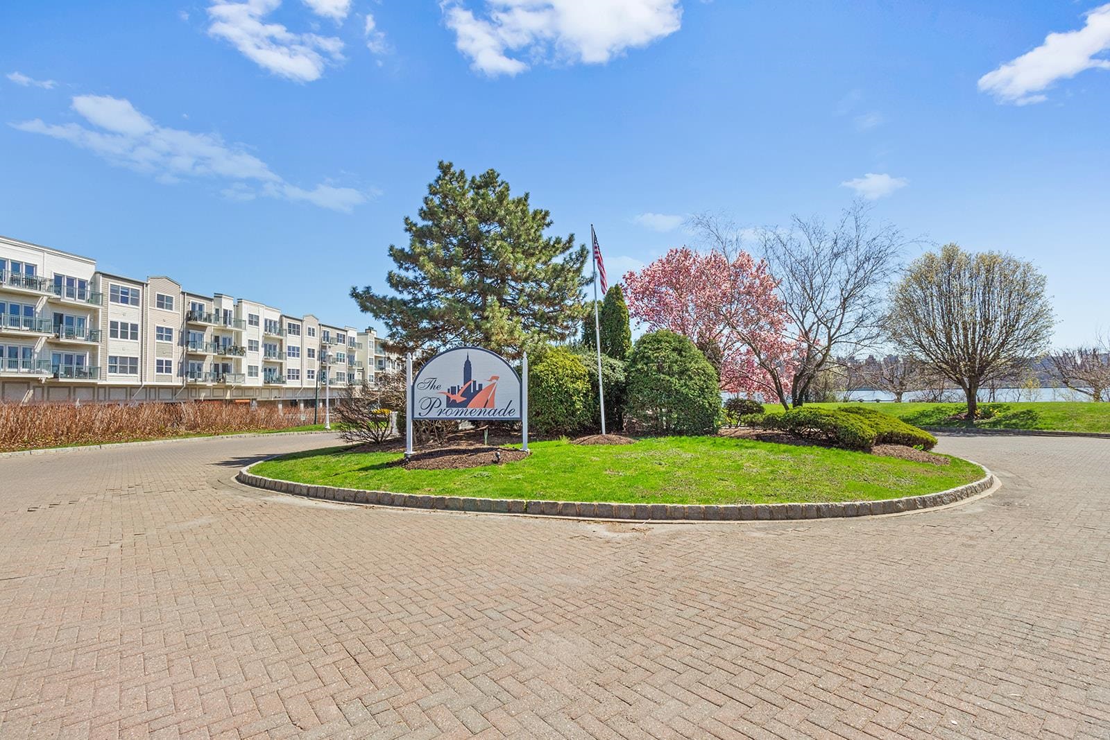 154 The Promenade, Unit 154 Edgewater, NJ 07020 - Photo 2 of 12 a front view of a house with a yard and trees