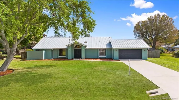 a front view of a house with a yard and trees