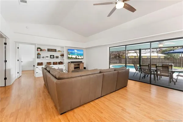 a living room with furniture and a large window with kitchen view