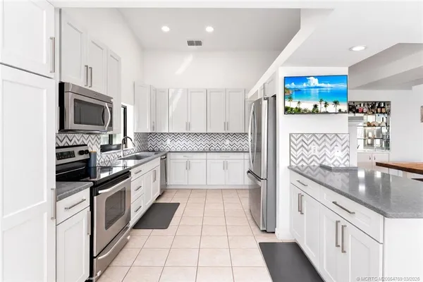 a kitchen with stainless steel appliances granite countertop a refrigerator and a stove top oven