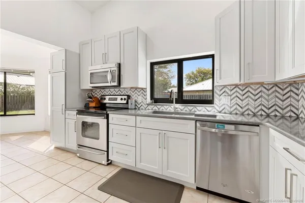 a kitchen with white cabinets and white appliances