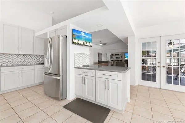 a kitchen with white cabinets and refrigerator