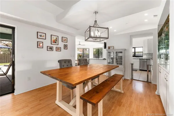 a living room with stainless steel appliances kitchen island a table and chairs in it