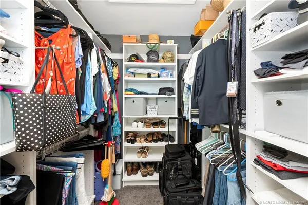 a view of walk in closet with clothes and shoes