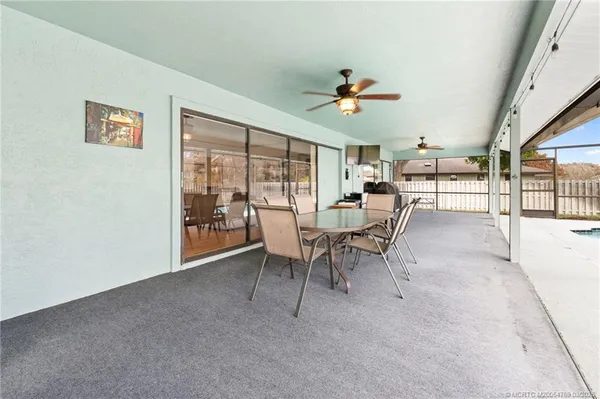 a dining room with furniture and a floor to ceiling window