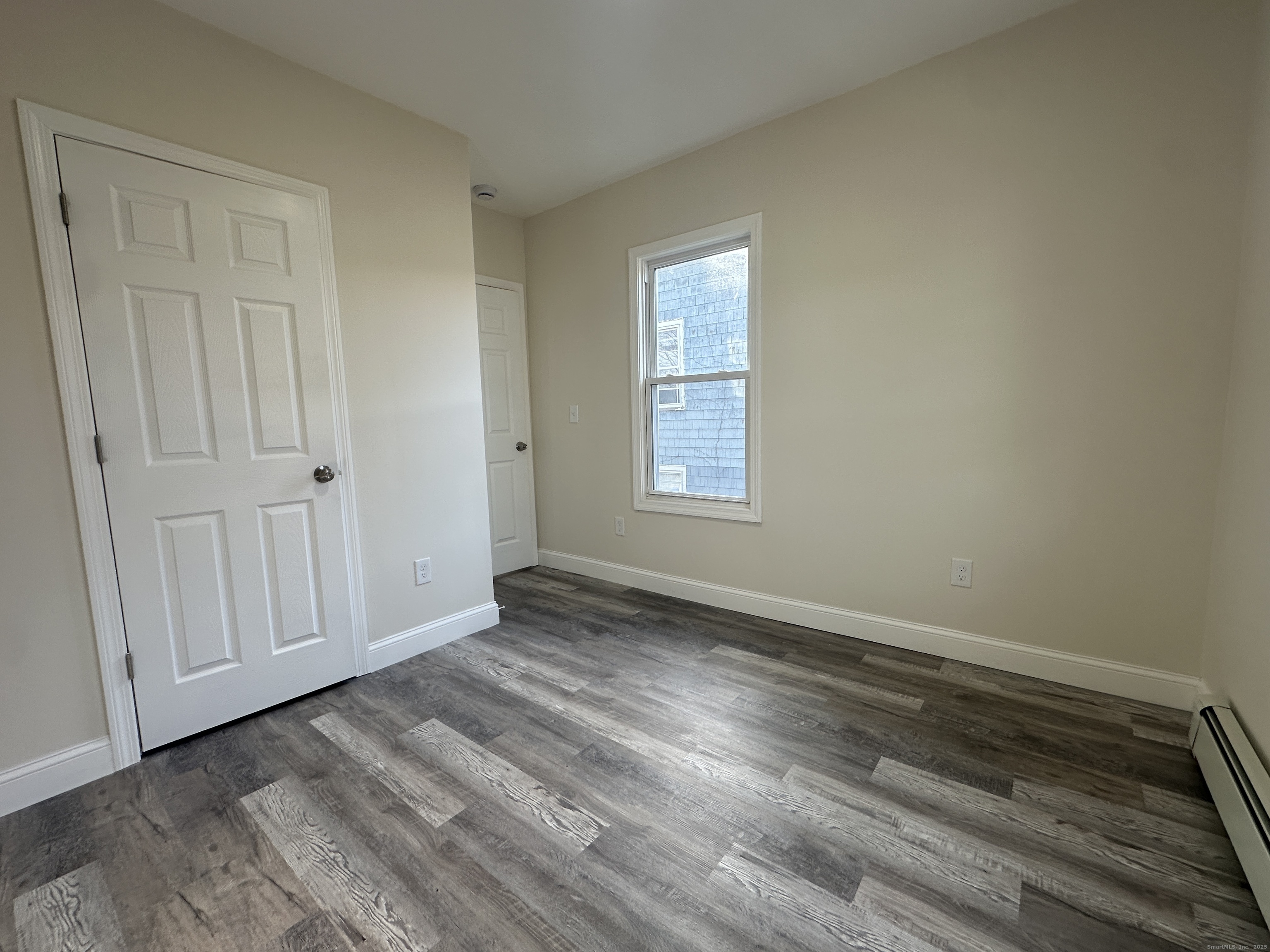 85 Twiss Street Meriden, CT 06450 - Photo 19 of 23 an empty room with wooden floor and windows