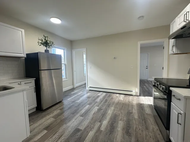 a kitchen with a refrigerator and a stove top oven