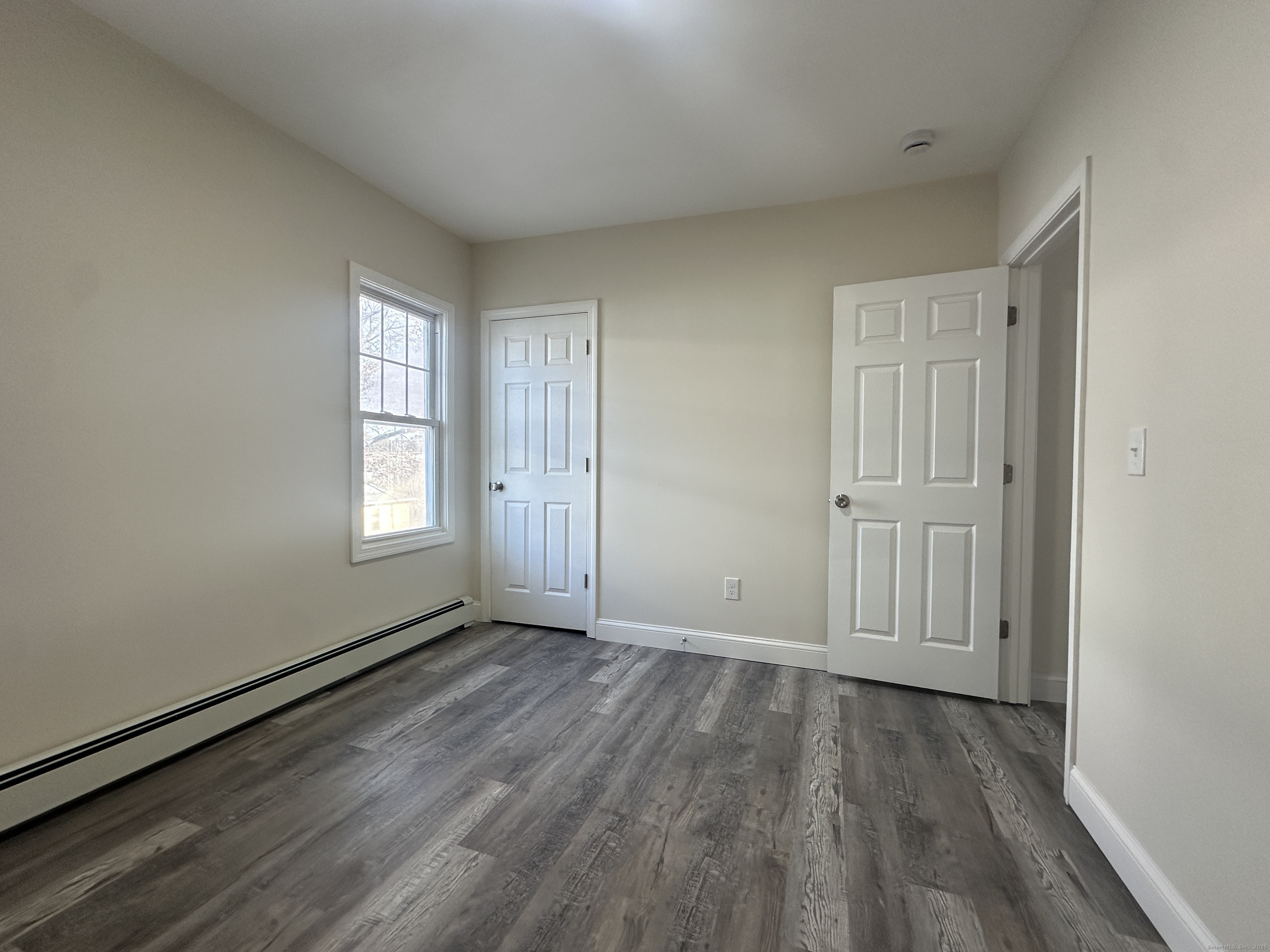 85 Twiss Street Meriden, CT 06450 - Photo 7 of 23 an empty room with wooden floor and windows