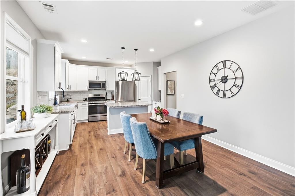 238 Observation Pointe Dallas, GA 30132 - Photo 11 of 41 a kitchen with stainless steel appliances a dining table chairs stove and cabinets