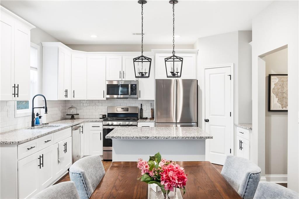 238 Observation Pointe Dallas, GA 30132 - Photo 13 of 41 a kitchen with stainless steel appliances kitchen island granite countertop a sink a stove a refrigerator and cabinets