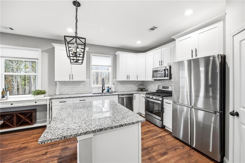 238 Observation Pointe Dallas, GA 30132 - Photo 16 of 41 a kitchen with stainless steel appliances granite countertop a refrigerator a sink dishwasher a oven with white cabinets and wooden floor