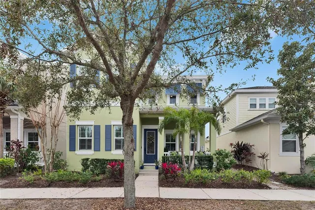 front view of a brick house with a large trees