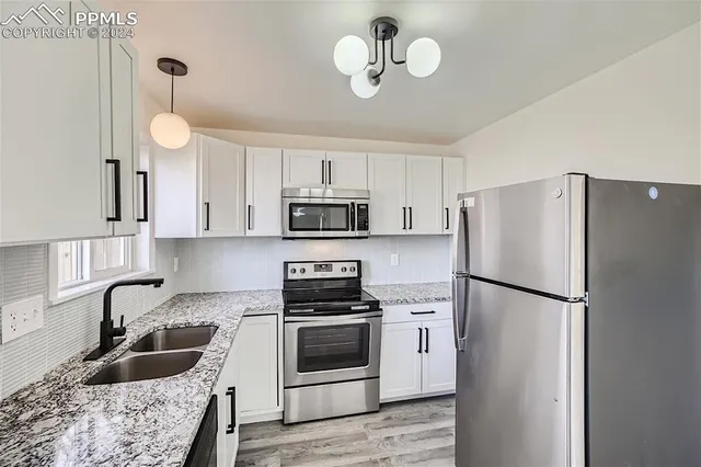 a kitchen with stainless steel appliances and white cabinets