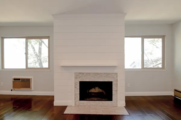 a living room with a fireplace and a floor to ceiling window
