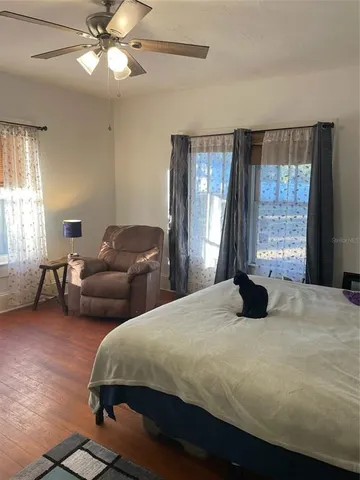 a bedroom with a bed couches and window