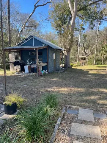 a view of a house with a yard and sitting area