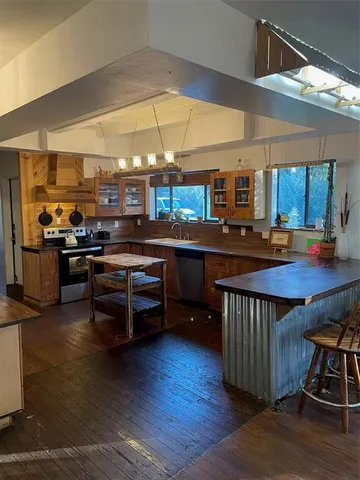 a kitchen with stainless steel appliances a table and chairs in it