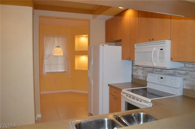 view of a kitchen with wooden floor and windows