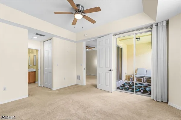 an empty room with windows and a ceiling fan