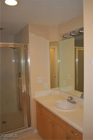 a bathroom with a shower sink and mirror