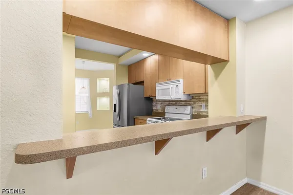 a kitchen with stainless steel appliances granite countertop a sink refrigerator and microwave