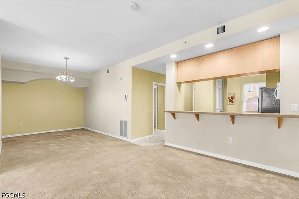 an empty room with kitchen and windows