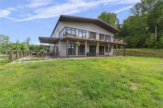 a view of a house with a big yard and large trees