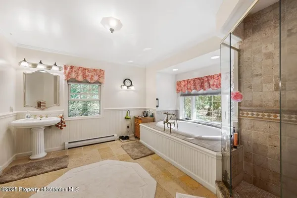 a spacious bathroom with a tub and large windows