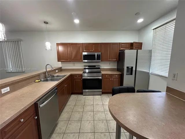 a kitchen with stainless steel appliances a refrigerator sink and stove