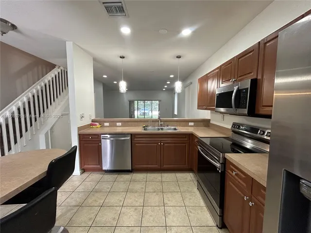 a kitchen with a sink stainless steel appliances and cabinets